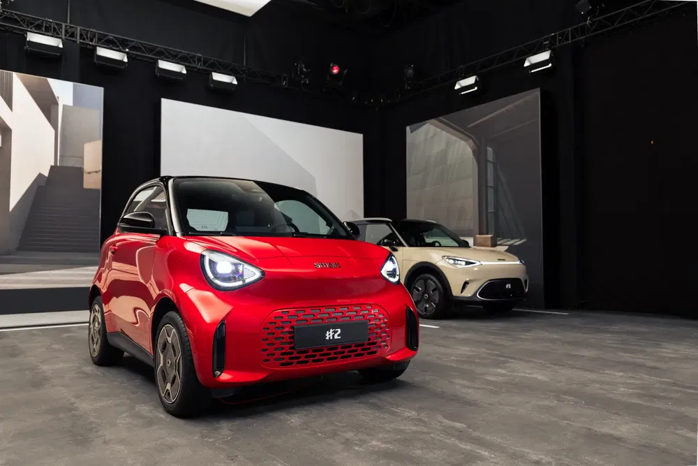 Twee moderne Smart #2-auto's tentoongesteld in een stijlvolle, minimalistische showroom.