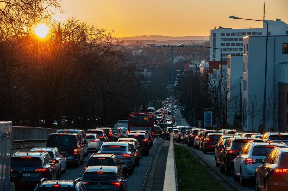 Embouteillage urbain au coucher du soleil avec voitures et bus en centre-ville.