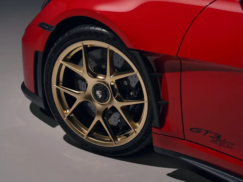 Jantes dorées Porsche GT3 RS rouges avec freins haute performance.