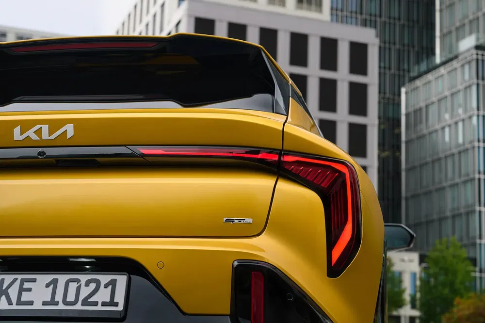 Vue arrière de la Kia Stinger GT jaune avec feux LED distinctifs en milieu urbain.