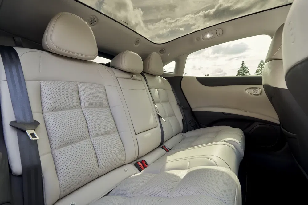 Intérieur de voiture de luxe avec sièges en cuir beige et toit en verre panoramique.