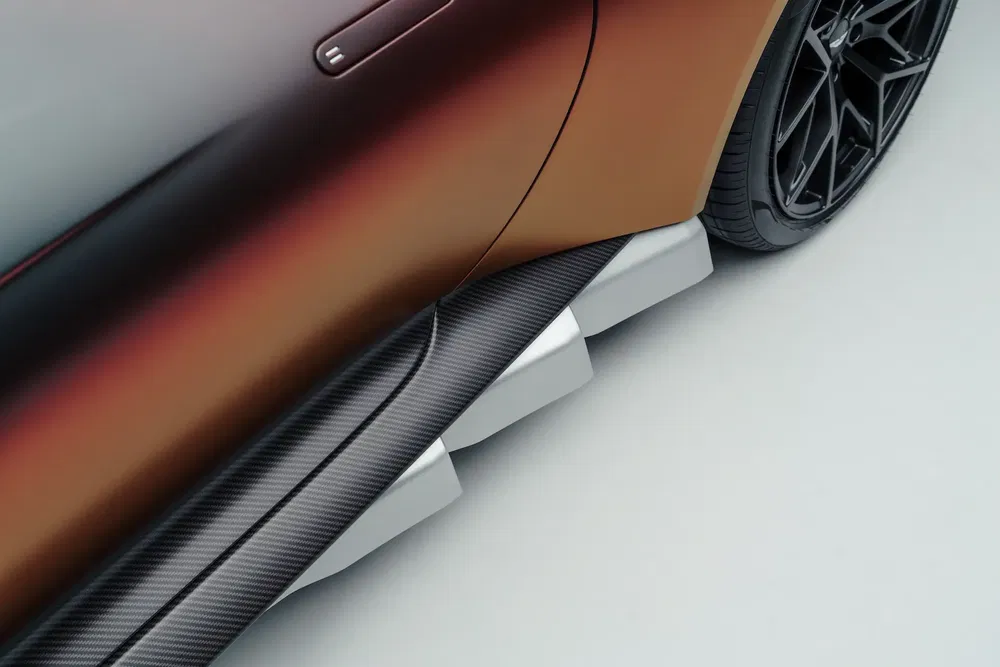 Vue rapprochée d'une voiture avec peinture dégradée et jantes noires élégantes.
