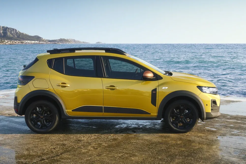 Vue latérale de la Dacia Sandero Stepway jaune sur fond de mer.