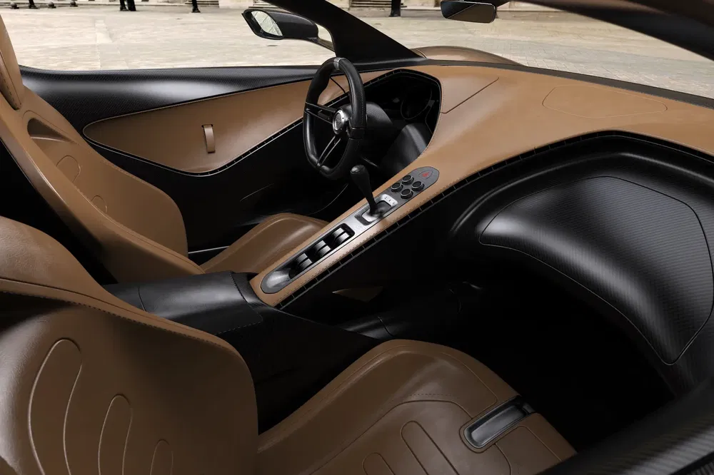 Luxe interieur van een hypercar met beige lederen stoelen en stijlvol vormgegeven stuur.