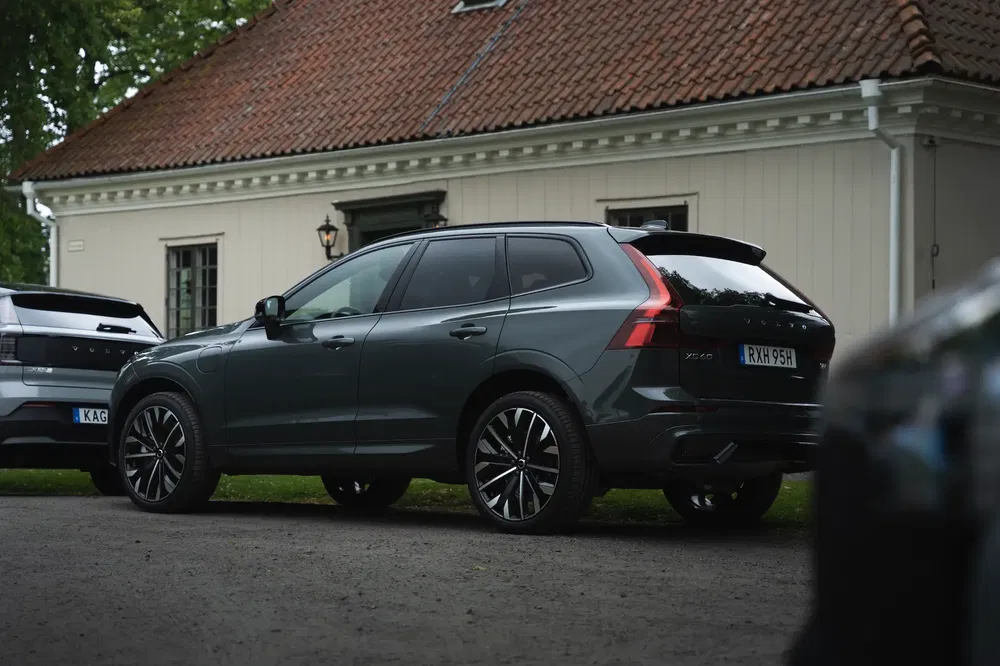 Volvo XC60 gris stationné devant une maison blanche avec toit en tuiles.