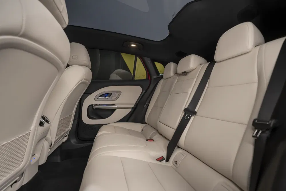 Intérieur élégant d'une Mercedes-Benz EQE avec sièges en cuir beige dans l'habitacle arrière.