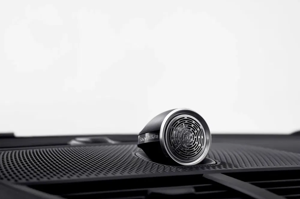 Haut-parleur automobile Bowers & Wilkins en gros plan sur une planche de bord moderne.