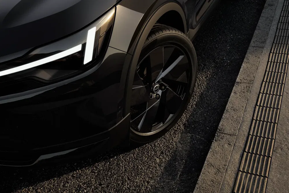 Volvo XC40 sombre élégant, gros plan sur phares LED et jantes alliage noir.