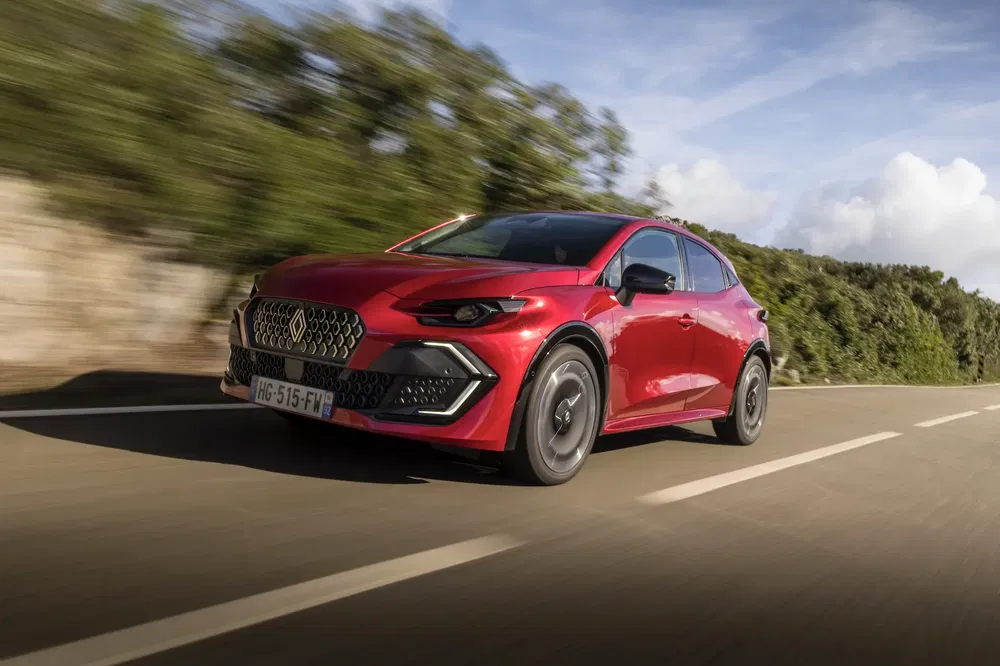 {"fr":"SUV rouge élégant en mouvement sur une route panoramique, ciel bleu partiellement nuageux.","nl":"Stijlvolle rode SUV in beweging op een panoramische weg, deels bewolkte blauwe lucht."}