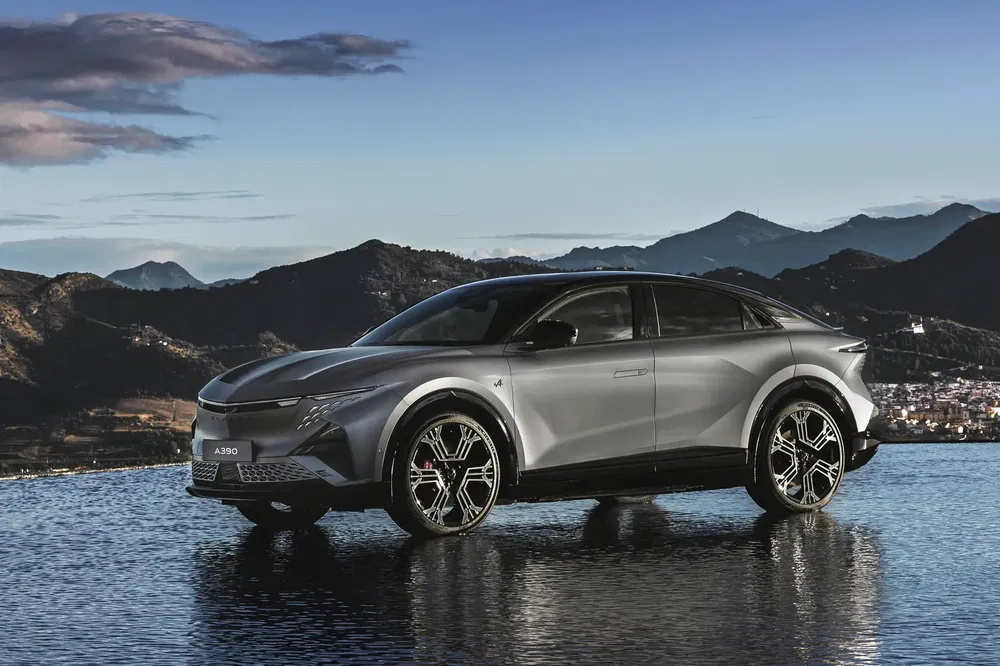 Peugeot A390 sur fond de montagnes, stationné sur une surface d'eau réfléchissante.