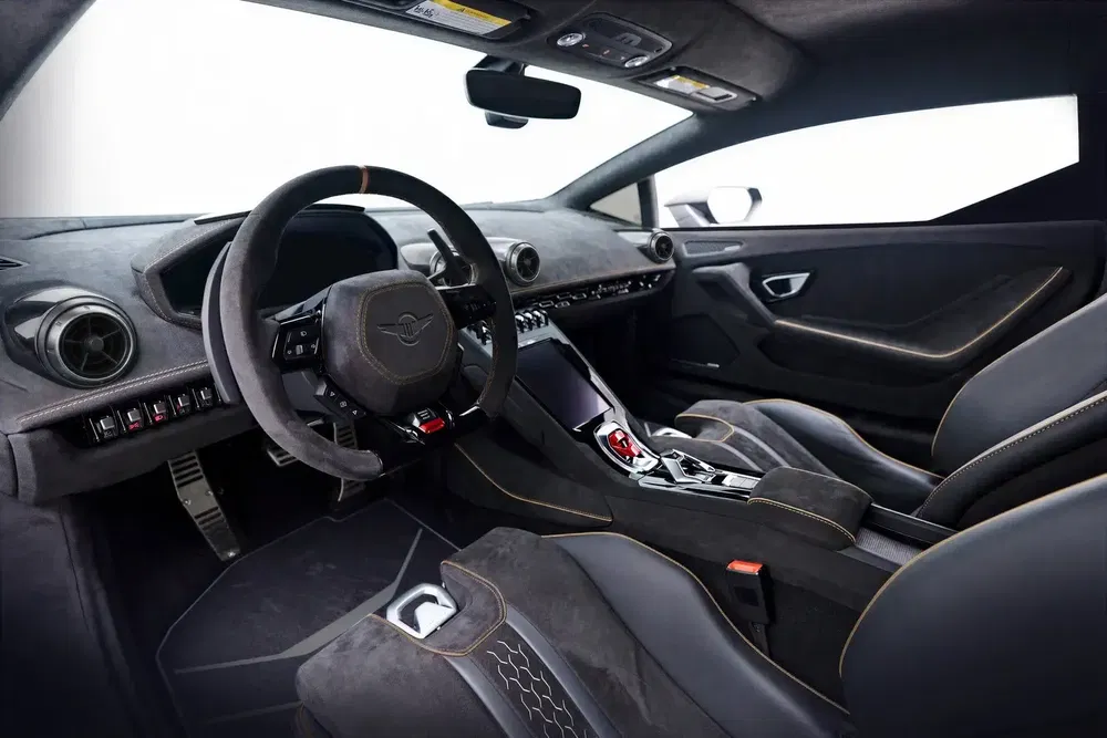 Intérieur luxueux d'une voiture Zenvo avec sièges en cuir noir et volant sportif.