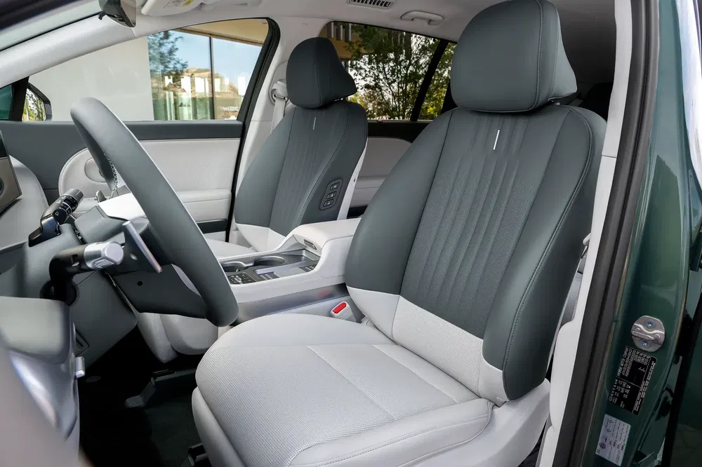 Vue intérieure d'un Hyundai Kona 2024 avec des sièges en cuir gris et tableau de bord élégant.