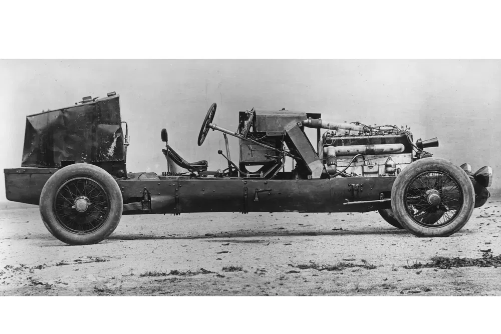 Châssis nu d'une voiture de course vintage avec moteur visible, années 1920.