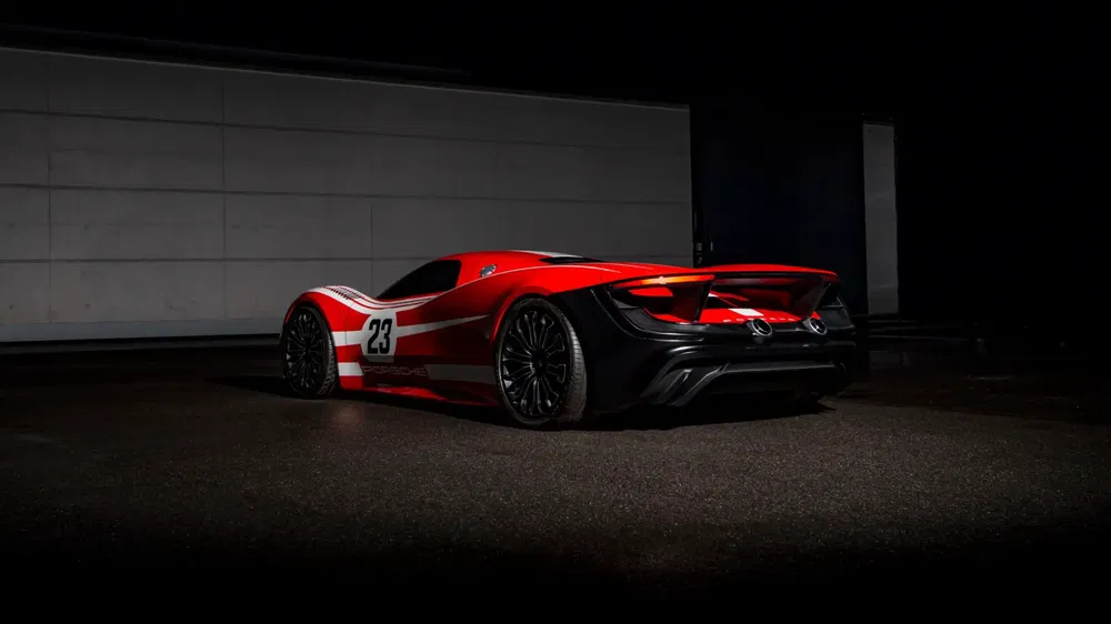 Voiture de sport rouge Porsche sur fond sombre avec le numéro 23 et bandes blanches.