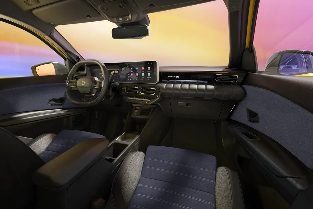 Intérieur moderne de la Renault 5 avec tableau de bord numérique et volant élégant.