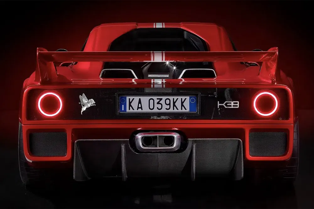 Vue arrière d'une voiture de sport rouge avec plaque d'immatriculation 'KA 039KK' et aileron.