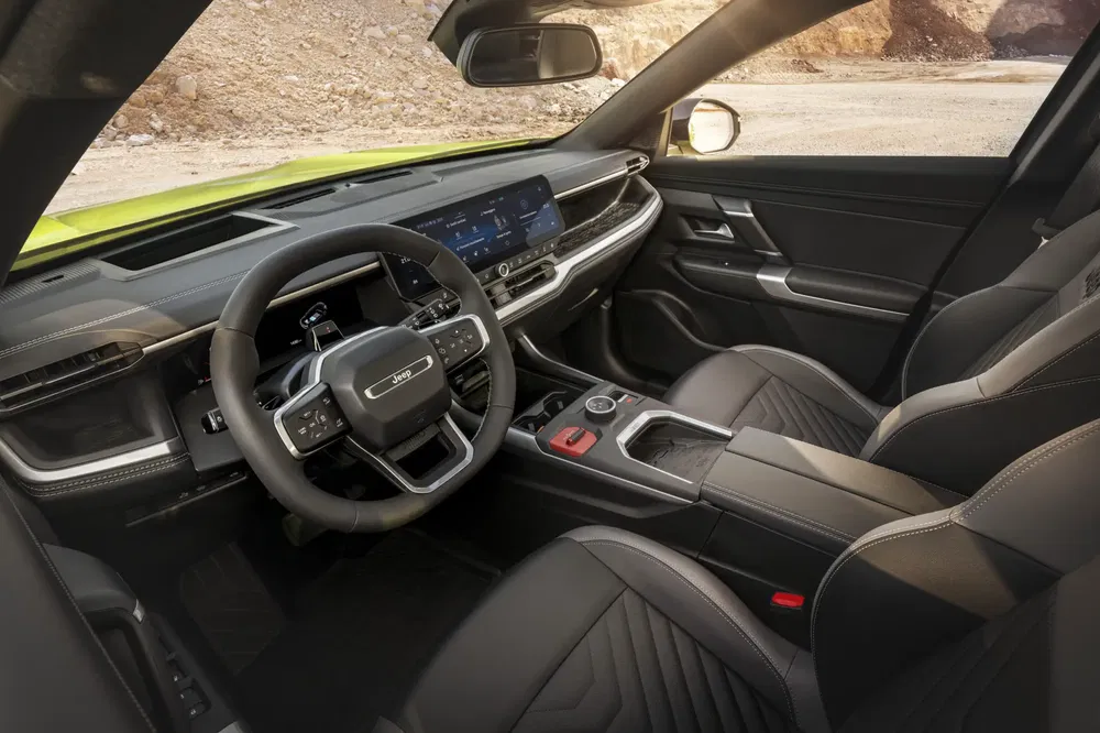Interieur van een SUV Jeep met modern digitaal dashboard en multifunctioneel stuur.