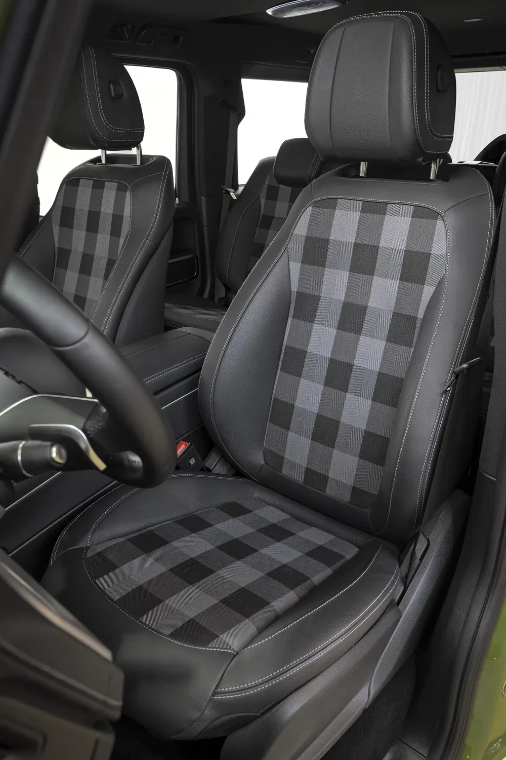 Interieur van een voertuig met chique zwart-grijs ruitjespatroon lederen stoelen.