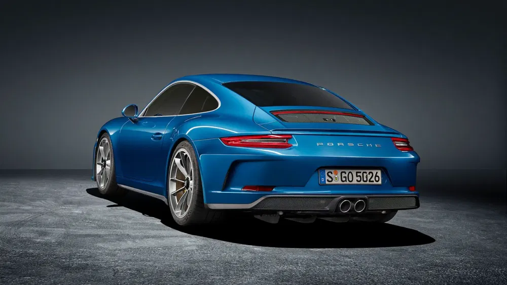 Porsche 911 bleue, vue arrière, sur fond sombre.