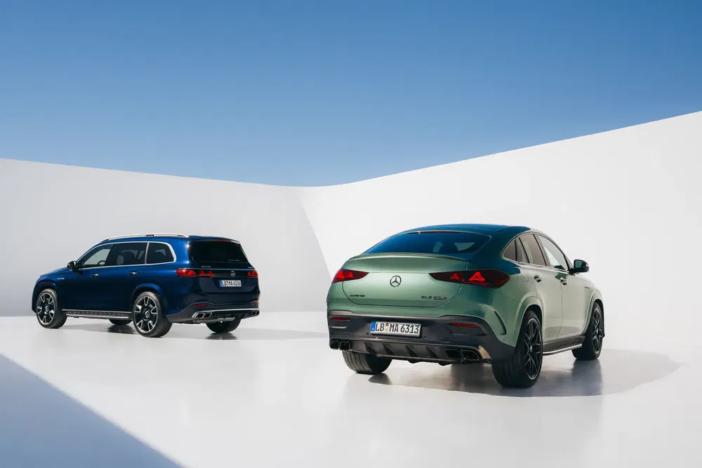 SUVs Mercedes-Benz GLE 2024 vert et bleu stationnés dans un espace au design moderne.