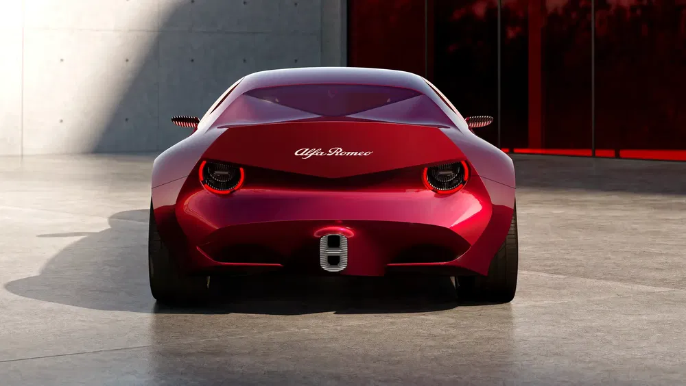 Arrière élégant de l'Alfa Romeo rouge moderne, garée devant un mur en béton.