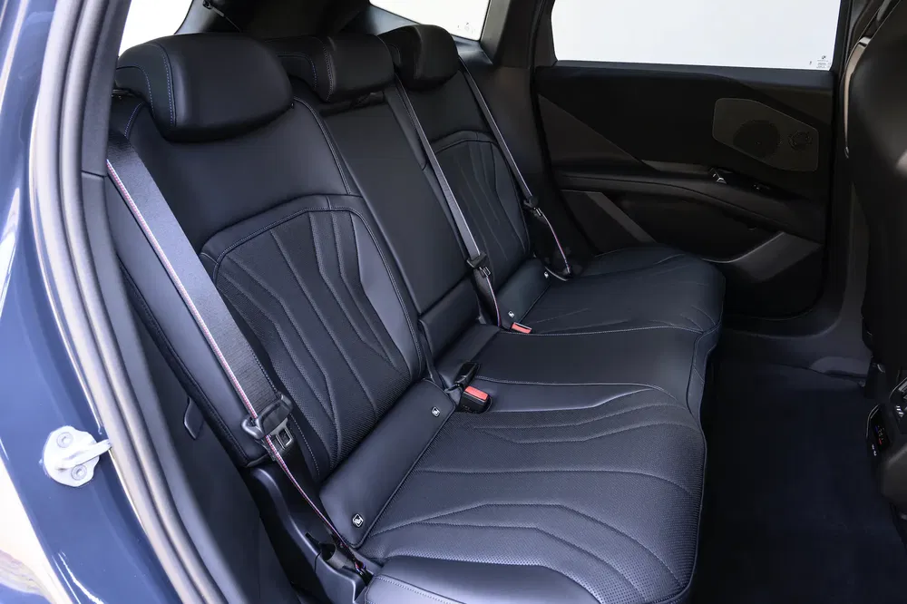 Intérieur de voiture moderne avec sièges arrière en cuir noir élégants et ceintures de sécurité.