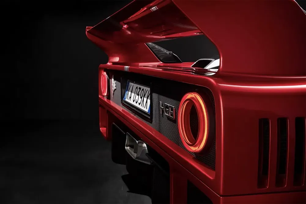 Vue arrière d'une Ferrari F40 rouge, dévoilant son aileron et feux arrière emblématiques.