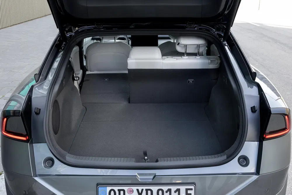 Coffre spacieux d'une Tesla Model Y avec sièges arrière rabattus pour espace de chargement.