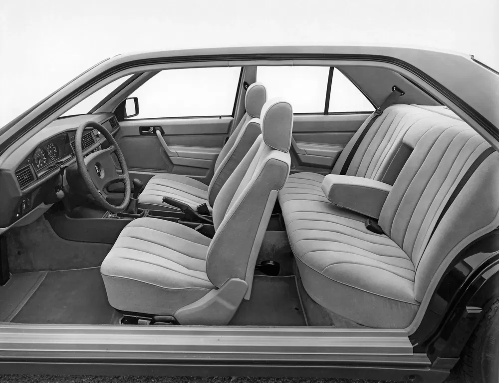 Intérieur de voiture vintage Mercedes-Benz avec sièges rembourrés et tableau de bord classique.