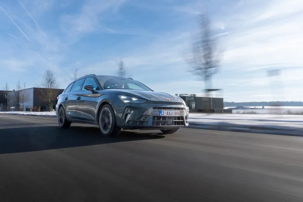 Elektrische Cupra Born rijdt op een besneeuwde weg onder een blauwe lucht.