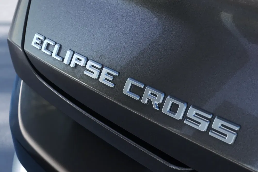 Achterlogo van Mitsubishi Eclipse Cross op grijze carrosserie.