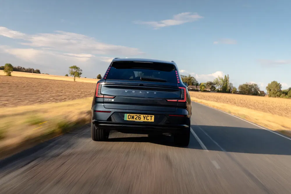 Volvo XC90 roulant sur une route de campagne ensoleillée.