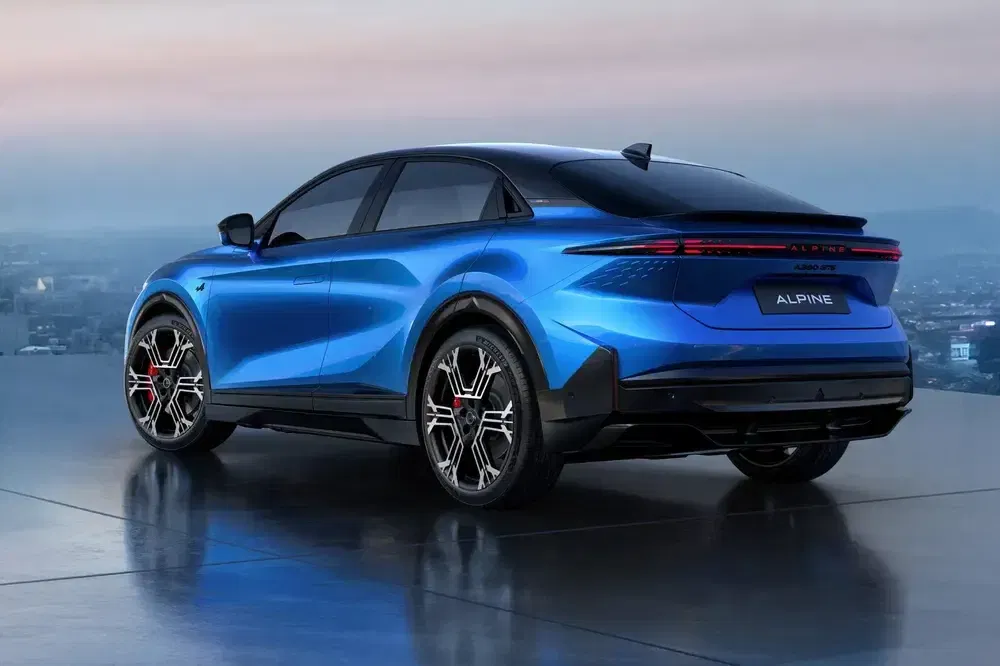 Véhicule électrique Alpine bleu moderne avec roues sport sur fond de paysage urbain.