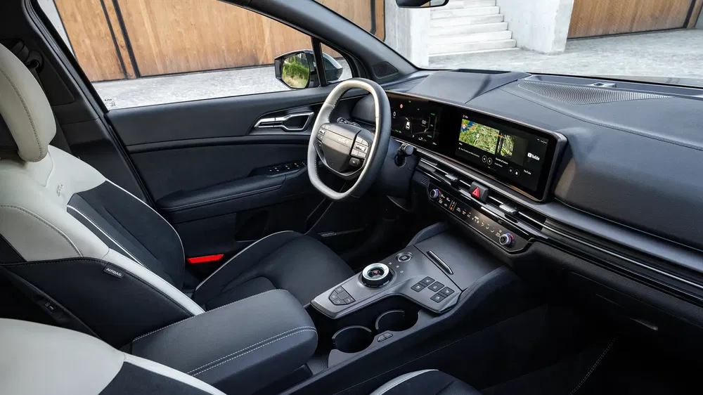 Intérieur moderne d'une voiture Kia EV6 avec tableau de bord numérique et sellerie bicolore.