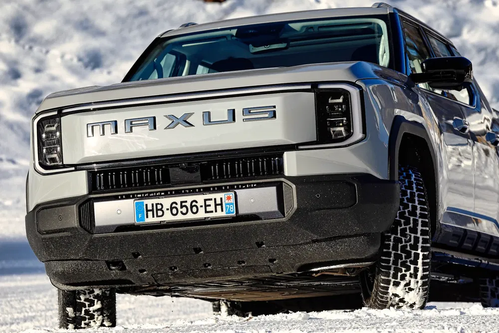 SUV Maxus argenté au design moderne sur fond enneigé.