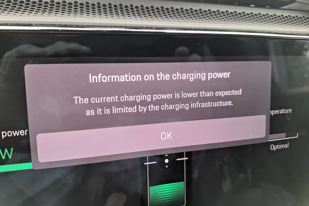 Avertissement affiché sur un écran de voiture concernant la puissance de charge réduite.