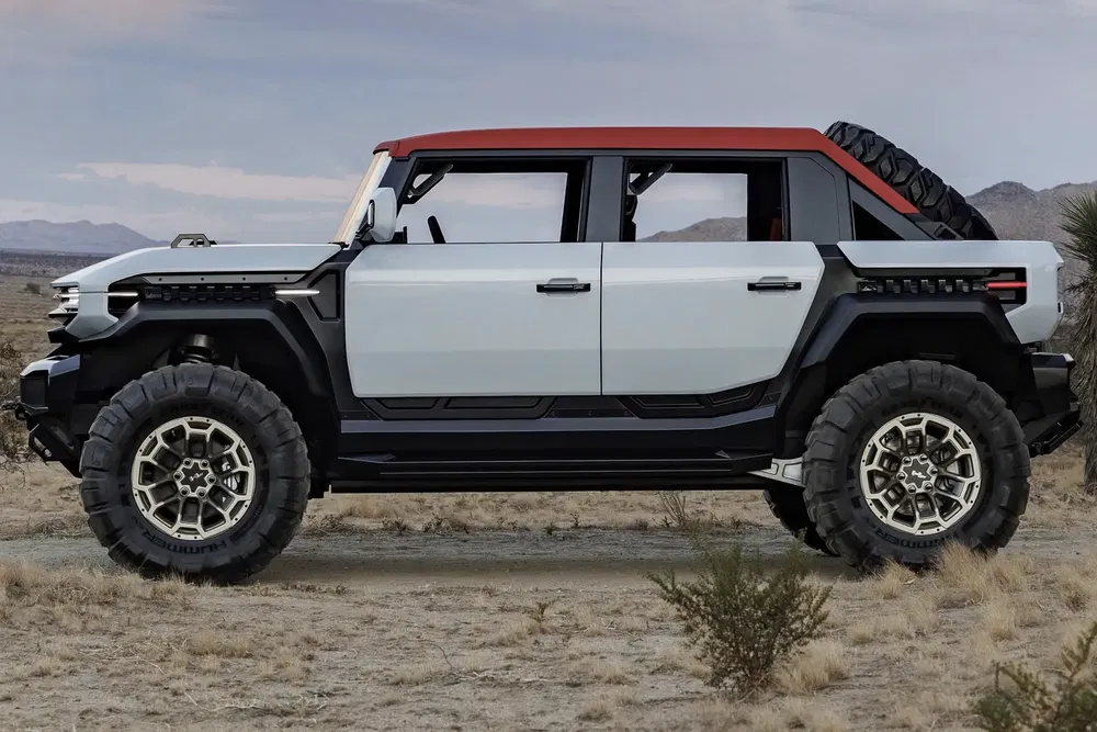 Hummer EV blanc avec toit rouge, en plein désert, design robuste tout-terrain.