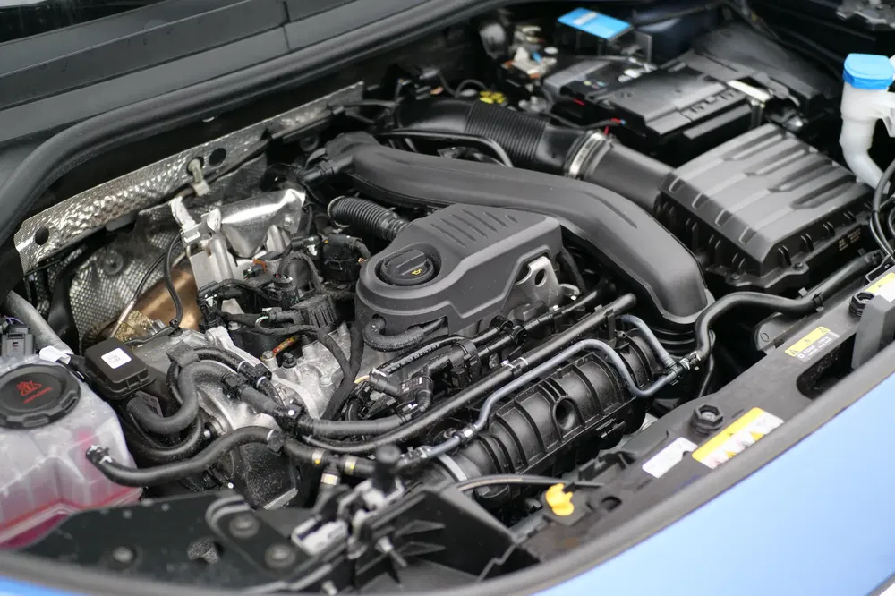 Peugeot-motor in detail, aanduiding van mechanische onderdelen onder de motorkap.