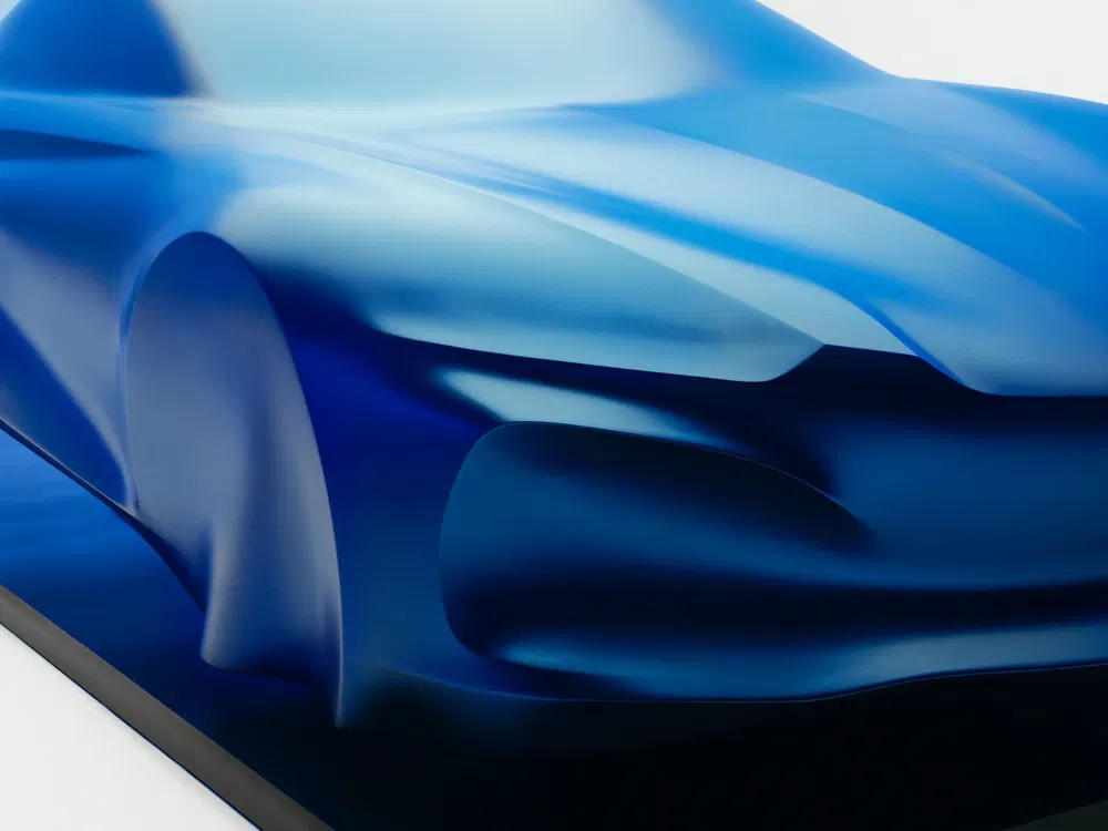 Sculpture aérodynamique 3D bleue d'une voiture sport futuriste en aluminium.