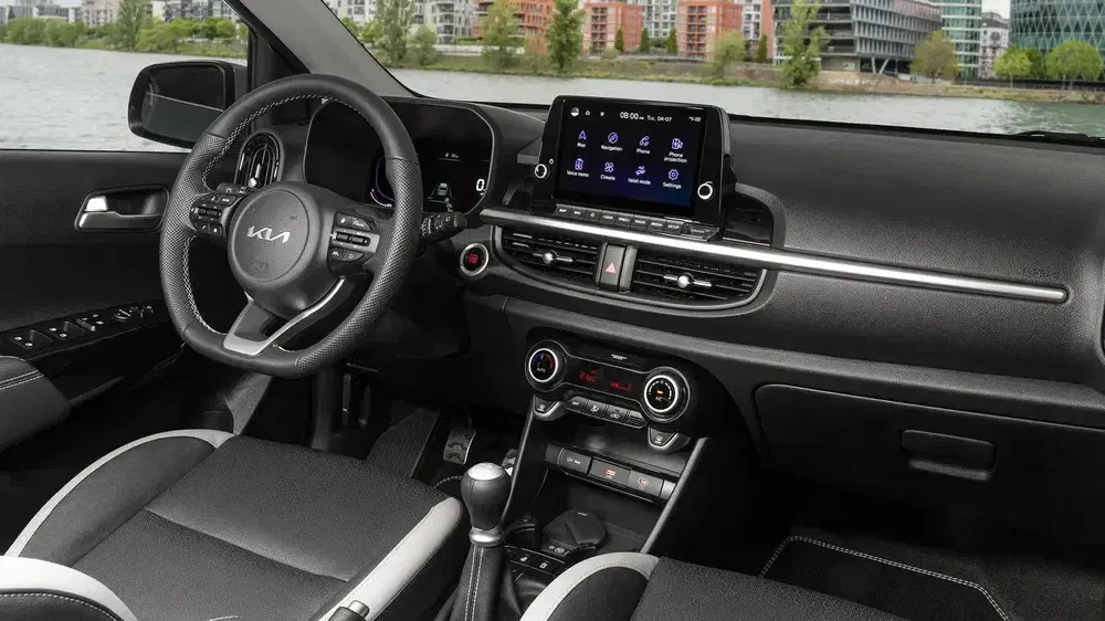 Intérieur d'une Kia moderne avec tableau de bord numérique et écran tactile central.