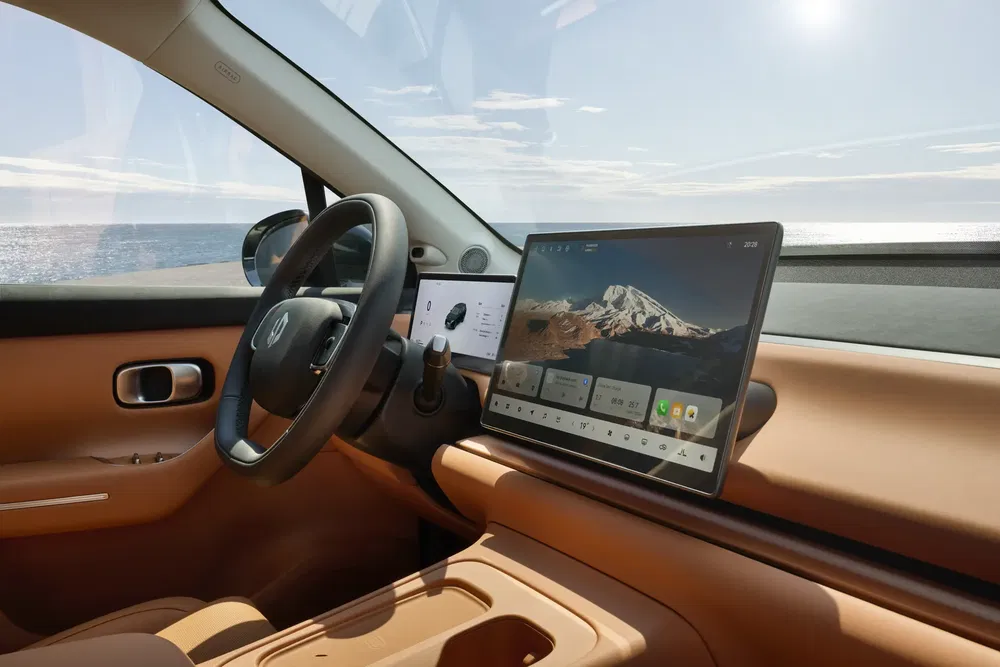 Intérieur de voiture HiPhi Y avec tableau de bord numérique et vue sur l'océan.