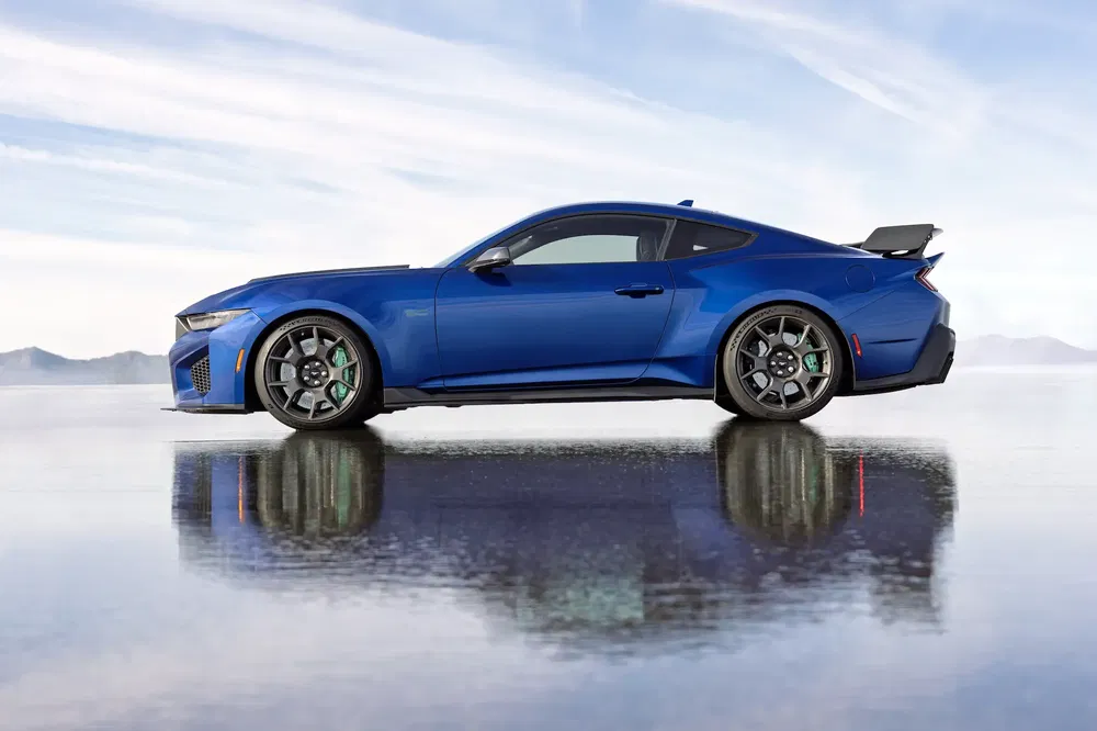 Ford Mustang GT bleue sur fond de paysage désertique arborant un aileron arrière distinctif.