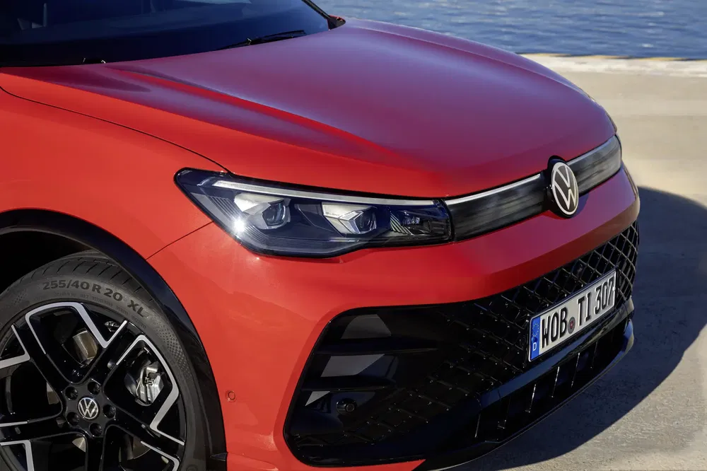 {"fr":"Volkswagen rouge avec phares modernes et jantes élégantes près de l'eau.","nl":"Rode Volkswagen met moderne koplampen en stijlvolle velgen bij het water."}