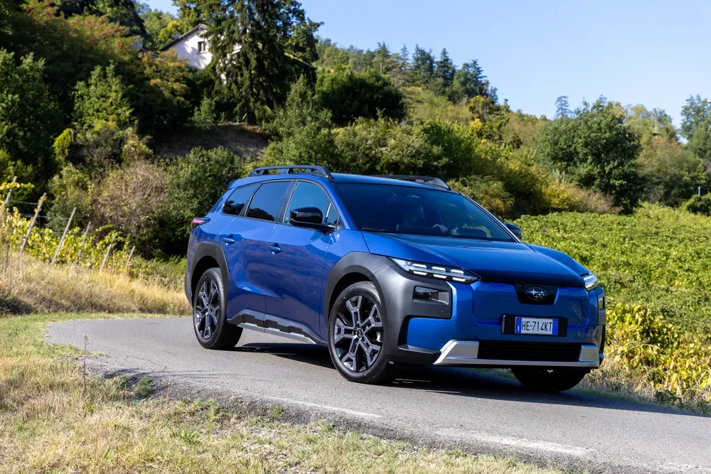 Citroën C5 Aircross bleu sur route de campagne entourée de végétation luxuriante.