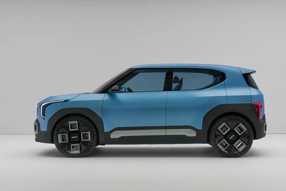 Profil latéral du SUV compact électrique Kia en bleu, design moderne et minimaliste.