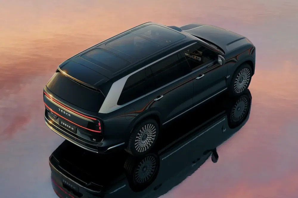 {"fr":"SUV Zeekr 009 moderne stationné, reflets sur surface d'eau au coucher du soleil.","nl":"Moderne Zeekr 009 SUV geparkeerd, weerspiegeling op watervlak bij zonsondergang."}