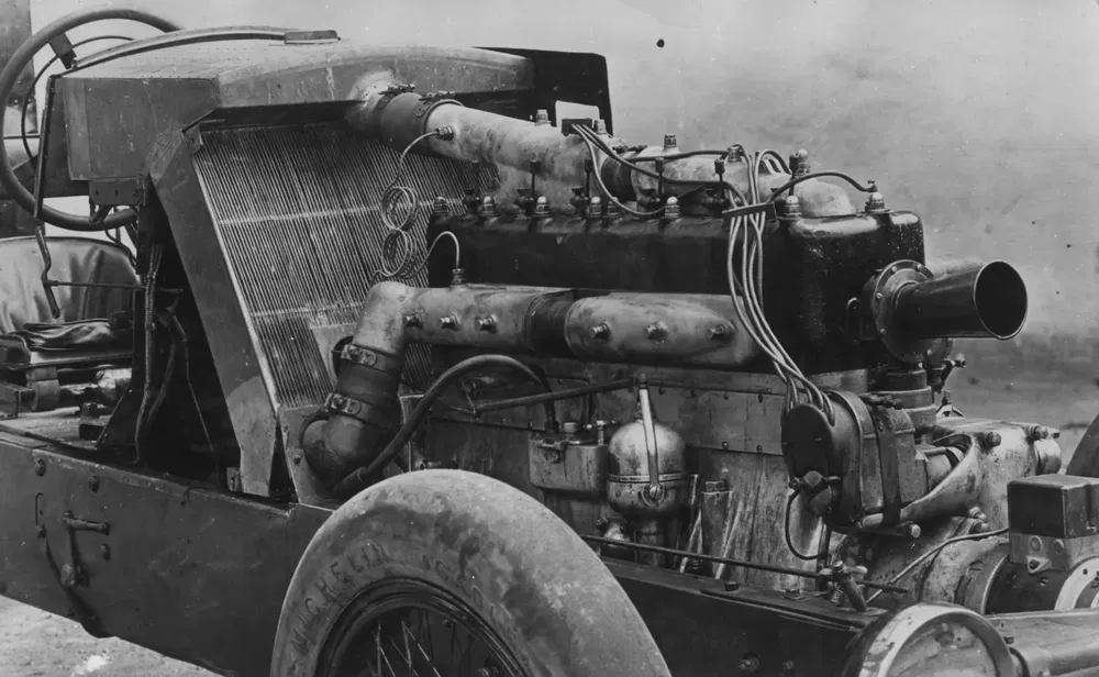 Ancien moteur de voiture exposé, avec composants mécaniques visibles, style rétro.