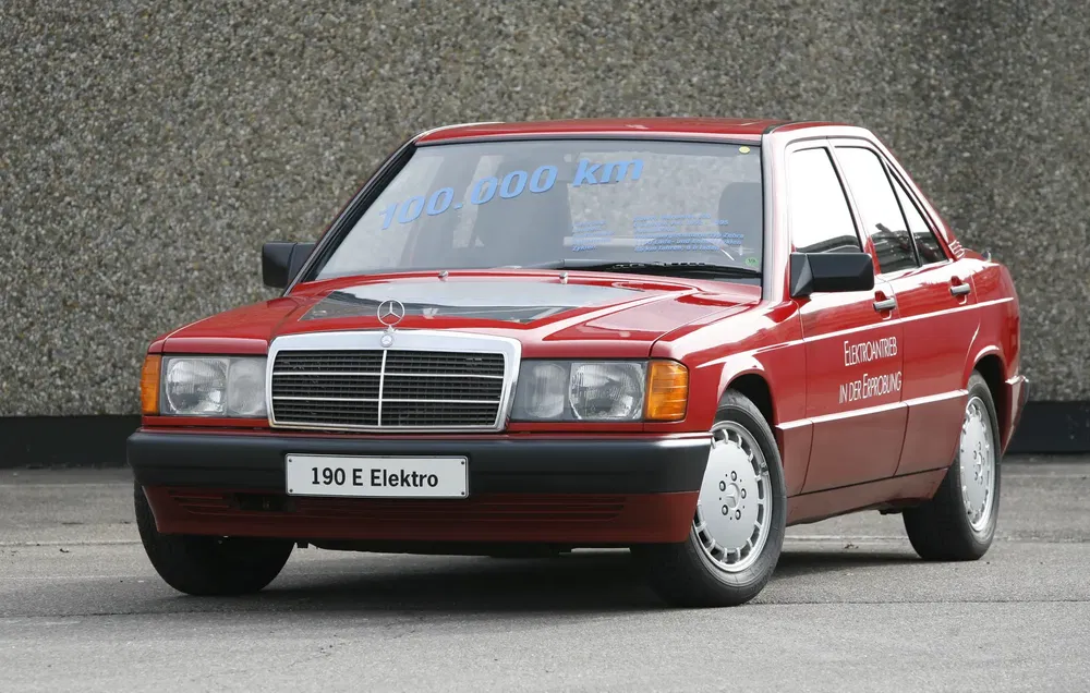 Mercedes 190 E Elektro rouge, concept électrique, 100.000 km affichés sur le pare-brise.