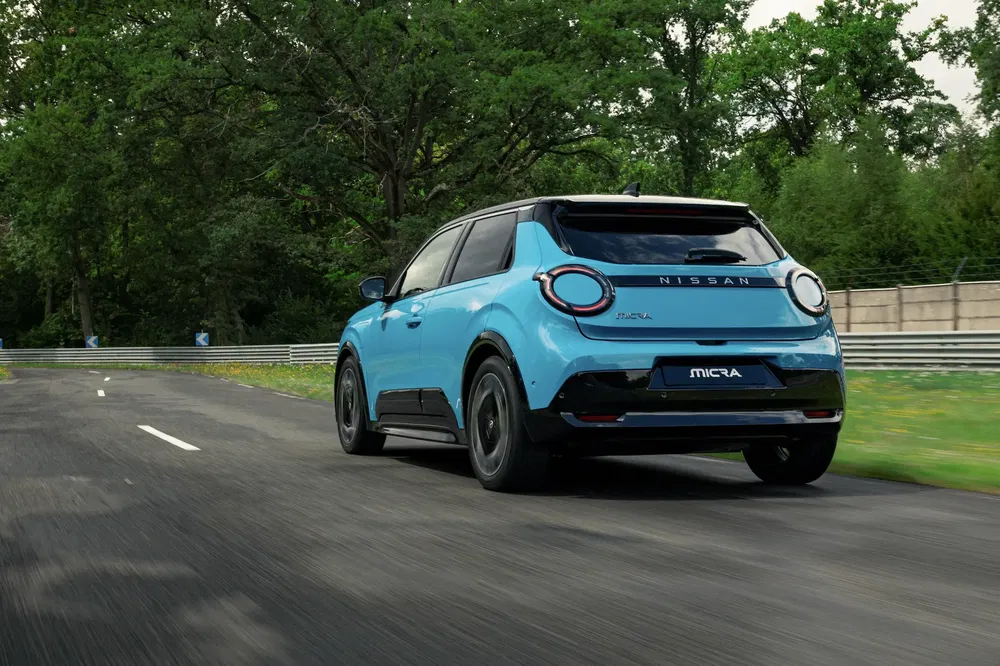 {"fr":"Nissan Micra bleu sur route entourée d'arbres, vu de derrière.","nl":"Blauwe Nissan Micra op weg omgeven door bomen, achterkant zichtbaar."}