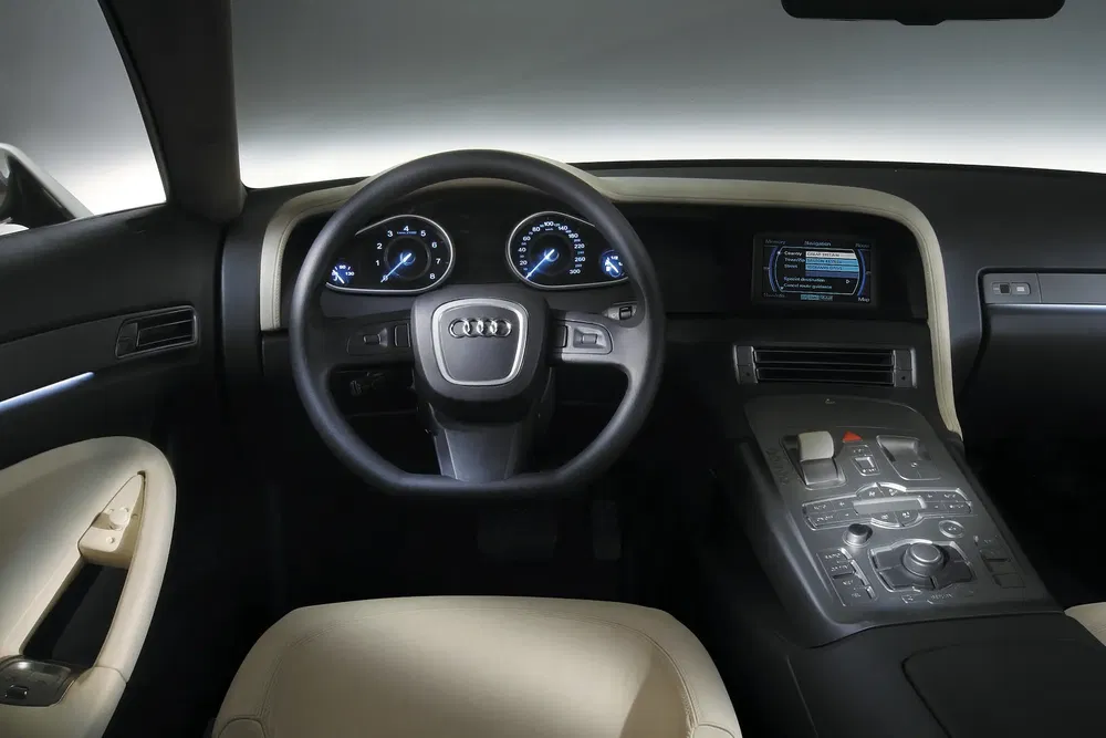 Intérieur luxueux d'une Audi avec volant et tableau de bord high-tech modernisé.